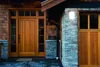 A close-up view of a house entrance with a wooden door and a garage door. Produktbild-Vorschau