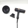 A black hairdryer with gold accents and two attachments are laid out on a white background. Podgląd zdjęcia produktu