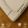 A close-up of a fitted sheet corner on a wooden floor, with various product feature icons and text overlays. Produktbild-Vorschau