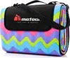 A rolled-up picnic blanket with a zigzag pattern and a black carrying strap and flap with a logo. Produktbild-Vorschau
