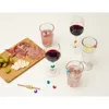 A charcuterie board with grapes, cheese, and cured meats, alongside several glasses of drinks with colorful glass markers. Podgląd zdjęcia produktu