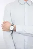 A man wearing a light blue dress shirt and a watch. Podgląd zdjęcia produktu