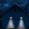 Two solar-powered wall lights illuminate a garage door at night. Produktbild-Vorschau