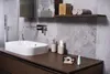 A modern bathroom countertop with a sink, toiletries, and a smartphone displaying a dental app. Produktbild-Vorschau
