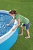 A woman is placing a blue solar cover on an inflatable pool. Produktbild-Vorschau