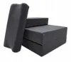 A dark gray foldable cushion or pillow next to stacked cushions. Náhled obrázku produktu