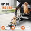 Three dogs of different sizes are shown on a set of pet stairs next to an open car trunk. Podgląd zdjęcia produktu