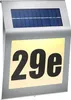 A solar-powered house number light with the number "29e" illuminated. Produktbild-Vorschau