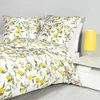A close-up view of a bed with a duvet and pillows featuring a lemon and floral pattern. Produktbild-Vorschau