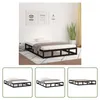 A black metal bed frame with a mattress and bedding in a room with artwork on the wall. Produktbild-Vorschau