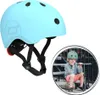 A light blue helmet is shown on the left, and a child wearing a green helmet is sitting on stairs on the right. Voir les images du produit