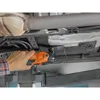 A person is using an orange oscillating tool to cut away material from the underside of a vehicle. Produktbild-Vorschau