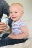 A baby is being held by an adult, and the adult is using a nasal aspirator on the baby. Produktbild-Vorschau