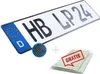 A German license plate with a carbon fiber look, along with a small circular inset showing a magnified view of the carbon fiber texture, and a stack of documents with a "GRATIS" stamp. Produktbild-Vorschau