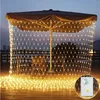 Outdoor patio area at dusk with a large umbrella decorated with a net of warm white fairy lights. Voir les images du produit