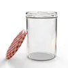 A clear glass jar with a red and white checkered lid is shown against a white background. Voir les images du produit