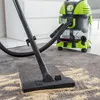 A wet and dry vacuum cleaner is being used to clean a carpet with debris on it. Anteprima dell’immagine prodotto