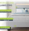 A close-up view of a white bed with a headboard featuring LED lighting, with descriptive text overlays highlighting its features. Produktbild-Vorschau