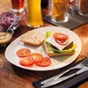A deconstructed burger and fries on a table with drinks. Produktbild-Vorschau