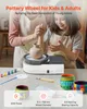 A person and a child are using a pottery wheel, with art supplies and finished pottery pieces on a table. Náhled obrázku produktu