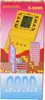 The image shows the packaging of a yellow electronic brick game console, with a cityscape illustration and the number '9999' at the bottom. Náhled obrázku produktu