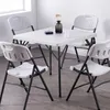 A square table with four chairs around it, set up in a room with natural light. Produktbild-Vorschau