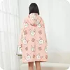 A person wearing a pink hoodie blanket with a rabbit pattern. Náhled obrázku produktu