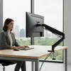 A woman is working at a desk with a monitor mounted on an arm. Anteprima dell’immagine prodotto