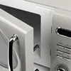 A close-up shot of a microwave oven with its door ajar, showing the control panel. Anteprima dell’immagine prodotto