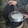 A person is holding a metal plate over an open storage bag, outdoors. Náhled obrázku produktu