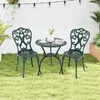 A green bistro set with two chairs and a table is placed on a lawn in front of a white wall, with string lights overhead. Náhľad obrázku produktu