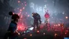 A female character in a blue cloak faces a large, monstrous creature in a dark, mystical forest setting. The scene is illuminated by numerous glowing red and orange particles floating in the air. Produktbild-Vorschau