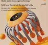 A close-up shot of an orange and gray head massager with promotional text overlaid. Produktbild-Vorschau