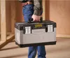 A person is carrying a Stanley Fatmax toolbox in a construction environment. Voir les images du produit