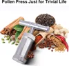 A metal pollen press surrounded by various spices and herbs. Produktbild-Vorschau