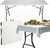 A white folding table is shown in its folded and unfolded states, with a second table set up with a tablecloth and food.