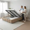 A couple is putting bedding into a bed frame with storage. Produktbild-Vorschau