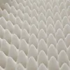 A close-up, abstract view of a white, textured surface with a repeating pattern of raised, conical shapes. Produktbild-Vorschau