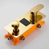 A close-up studio shot of a gold-colored shower faucet system with an orange plastic base. Podgląd zdjęcia produktu