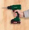 A person is holding a cordless drill and drilling into a wooden surface. Produktbild-Vorschau
