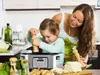 A mother and child are in a kitchen preparing food with a multi-cooker. Produktbild-Vorschau