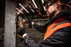 A man in safety gear using an angle grinder in a warehouse. Voir les images du produit