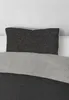 A close-up view of a pillow and bedding. Produktbild-Vorschau