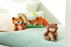 Two stuffed animals and a decorative pillow are arranged on a bed. Anteprima dell’immagine prodotto
