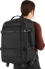 A person wearing a dark shirt is carrying a black backpack with wheels. Produktbild-Vorschau