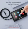A hand is shown interacting with a small electronic device that has a screen displaying various icons. A coiled audio cable is also visible. Náhled obrázku produktu