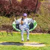A young girl is swinging on a green nest swing in a park. Náhľad obrázku produktu