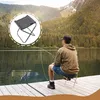 A person fishing on a dock with a small portable stool. Produktbild-Vorschau