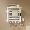 A white electric towel warmer mounted on a light brown wall, with towels, soap dispensers, and bath accessories displayed. Anteprima dell’immagine prodotto