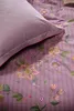 A close-up view of a floral patterned duvet cover and pillowcase. Produktbild-Vorschau